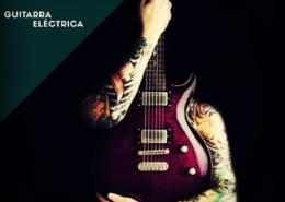 Los brazos de un hombre tatuado abrazando una guitarra eléctrica